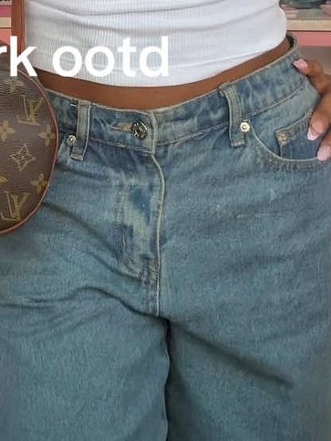 Mid-wash jeans worn with a shoulder bag